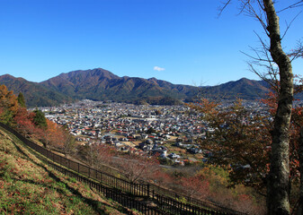 Wall Mural - A view of Fujiyoshida city with a backdrop of mountains from the Chureito Pagoda in Japan.