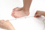 Fototapeta Miasta - 子供の足のサイズを測る様子