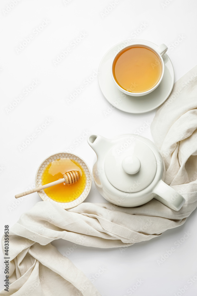 Composition with teapot, cup of tea and honey on white background