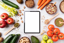 Top View Of A Tablet With White Screen For Mock Up With Healthy Foods