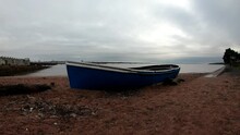 Neglected Blue Rowing Boat Timelapse Cloudscape On Sandy Dawn Beach Shoreline
