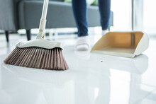 Sweeping Dust With Black Broom On A Wooden Floor