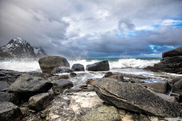 Beautiful landscape. Lofoten islands. Stones, waves on the background of  clouds and  mountains.