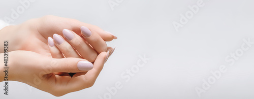 Female hands with rose nail design. Coral glitter nail polish manicure on white background. Nail design copy space.