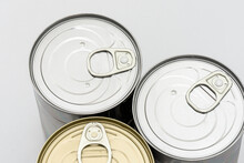 Three Tin Can (canned Food) On The Gray Background. 