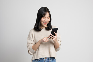 pretty young asian woman using smartphone standing on isolated w