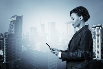 Wall Mural - Attractive black African American business woman in suit using smart phone and thinking how to tackle the problem, new career opportunities, MBA. Bangkok on background. Double exposure.