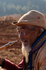 An old man holding a smoke gun