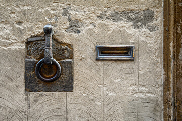 Wall Mural - Close-up of an antique wrought iron ring, used in the past for tie horses, and a letterbox on an old stone wall in the historic centre of Siena, Tuscany, Italy