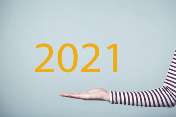 woman holding 2021 text in screen