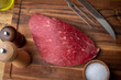 © ahirao - raw flank steak on wooden cutting board