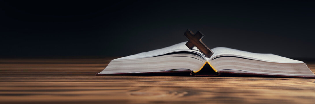 wooden cross on open Bible