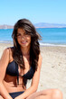 © boryanam - Young Woman with Sunglasses and Swimsuit Sitting on the Beach on a Sea Background