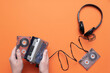 © Natali - Old retro stereo cassette player and headphones on the orange flat lay background.