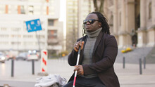 Blind Black Man Sitting On The Bench And Holding Walking Long Cane. High Quality Photo