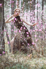 Poster - Japanese-style girl in a flowering forest among pink flowers in spring