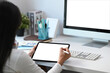 © Prathankarnpap - Rear view of female graphic designer working on digital tablet at her creative workspace.