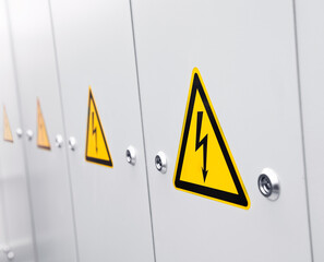 A row of lockers with warning sign high voltage.