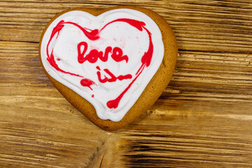 Wall Mural - Heart shaped gingerbread cookie on wooden table.  Top view. Dessert for valentine day