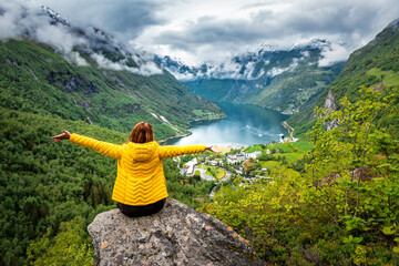 happy woman in yellow over geiranger fjord