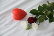 Rose blanche et rouge  bouquet de rose  posé sur un lit avec son  cœur 