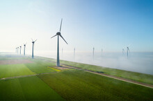 Offshore Wind Turbines Standing In Fog On The IJsselmeer Inland Sea, Land Based Turbines In The Clear, Flevoland, Netherlands