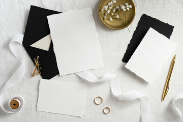 Wall Mural - Wedding invitation cards design. Set of blank paper cards, black envelopes, golden decorations on white textile background. Elegant wedding stationery.