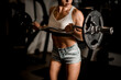 © fesenko - athletic hands of woman bodybuilder holding barbell and lifting it
