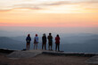 group of tourists standing in front of the sunset. On Nern Chang Suek, Kanchanaburi in Thailand.