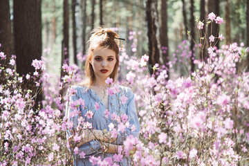 Wall Mural - Japanese-style girl in a flowering forest among pink flowers in spring