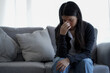 © KomootP - Depressed lonely unhappy mental woman sitting alone on the sofa at home with hand on face feel stress sad and worried disappointment while facing problem during coronavirus or covid-19 pandemic