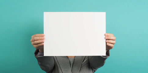 Empty space for text.Woman hands holding blank paper and wear grey suit isolated on blue and green background.