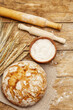 Fresh baked bread with wheat ears, bowl of flour and rolling pins