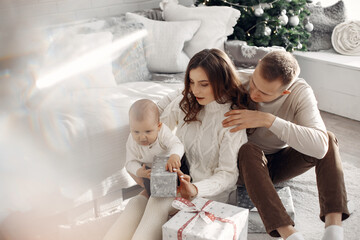 People preparing for Christmas. People sitting on the floor. Family is resting in a festive room.