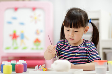 young girl decorating hand made craft for homeschooling