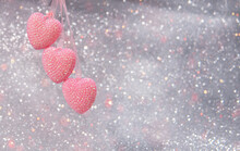 Three Pink Hearts On A Ribbon On A Gray Glitter