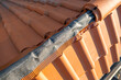 Closeup of yellow ceramic roofing ridge tiles on top of residential building roof under construction.