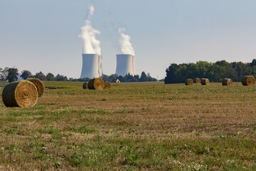 Wall Mural - Power plant with bales of hay on field.