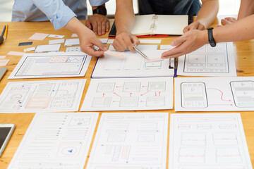 Graphic designers work together with UX UI designer planning application template layout framework for mobile phone computer mobile