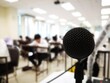 © Chinnadit - Microphone in class while teaching There is a blurry image for students in the background.