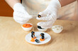 Woman’s hands preparing a healthy food.
Ingredients for making a skewer snack made from olives, curd cheese and carrots in the shape of a penguin. Step 1