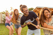 © Impact Photography - Friends playing tug of war at an outdoor summertime party