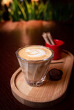 Fototapeta Kwiaty - flat white coffee served on wooden coffee tray. glass of cappuccino served on wooden coffee tray with chocolate truffle.  