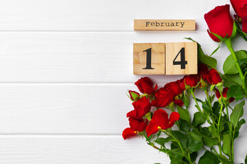 Wooden calendar 14th February and roses on white background