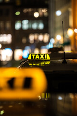 Canvas Print - Vertical shot of the yellow TAXI signs on the taxis captured at night