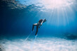 © artifirsov - Attractive woman freediver with white fins posing underwater in sea.