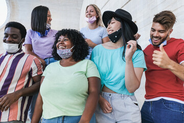 Wall Mural - Happy multiracial friends dancing together outdoor while wearing protective face masks under chin - Coronavirus lifestyle and social distance concept