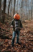 Man Wearing Scary Carved Pumpkin Head In The Woods For Halloween.
