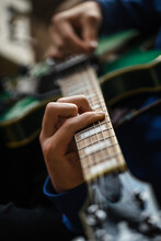 Close Up Of Fingers, Strings And Frets Of Guitar