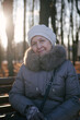 © DariaTrofimova - Senior woman  smiling while sitting on park bench